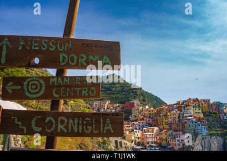 Uno splendido scenario con cartelli di legno nella città di Manarola, il Parco Nazionale delle Cinque Terre, Liguria, Italia. Si tratta di uno dei cinque famose pittoresche colorati Foto Stock