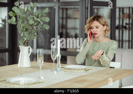 Bionda ragazza chiamando il suo uomo e avente lite Foto Stock