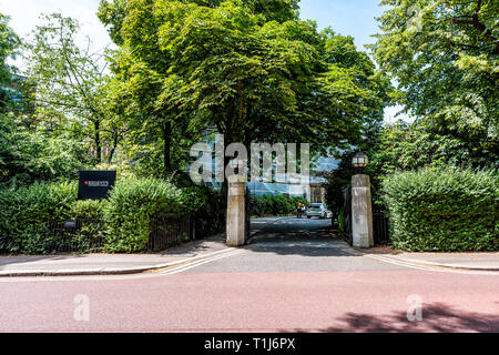 London, Regno Unito - 24 Giugno 2018: Regent's Park durante la giornata estiva con strada e Università firmano e ingresso al college Foto Stock