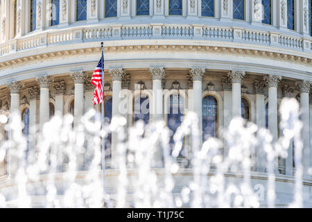 Il Congresso Usa closeup con sfondo di fontana acqua spruzzi bandiera americana sventolare a Washington DC, Stati Uniti d'America sul capitale Capitol Hill colonne pilastri Foto Stock