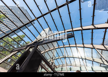 London, Regno Unito - 26 Giugno 2018: scale mobili fino all'interno della metropolitana metro durante la mattina i pendolari Canary Wharf segno con architettura moderna Foto Stock