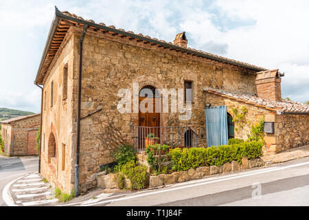 Val D'Orcia campagna in Toscana con vuoto street nel piccolo centro abitato con nessuno e piante sulla pietra tipica casa in Querce al Pino, Italia Foto Stock