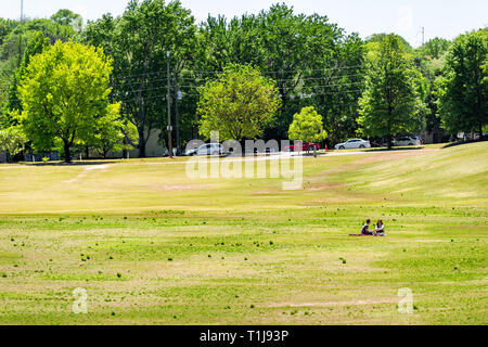 Atlanta, Stati Uniti d'America - 20 Aprile 2018: vista in Piemonte Park in Georgia downtown con scenic verdi alberi, erba e giovane seduto sul terreno in estate Foto Stock