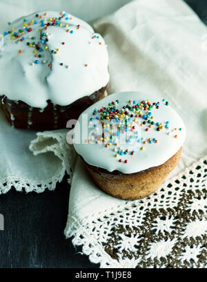 Pasqua tradizionale cottura dell'Ucraina con il bianco glassa di zucchero e un decor colorato su un asciugamano di tessili con pizzo Foto Stock