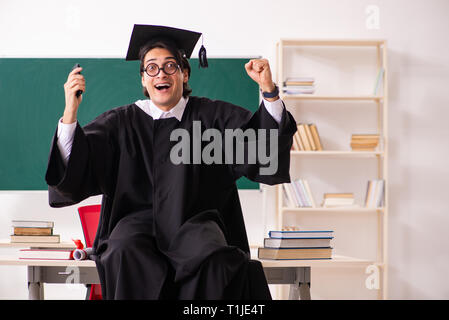 Studente laureato nella parte anteriore della scheda verde Foto Stock