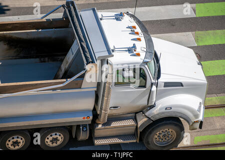 Potente big rig carrello punta con l'opzione della copertura di carichi alla rinfusa si muove su strade di città con attraversamento pedonale i contrassegni al lato del lavoro per caricoin Foto Stock