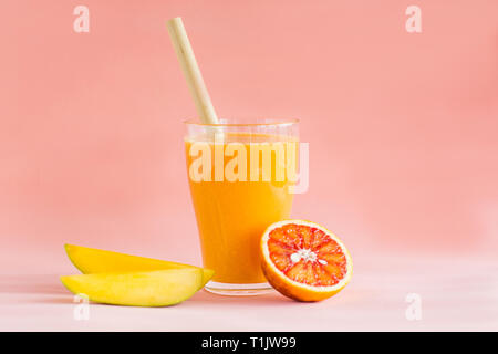Bicchieri di mango, succo d'arancia su sfondo rosa. Rinfreschi e bibite estive. Vitamine e minerali concetto. Bibita salutare. Foto Stock