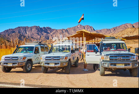 DAHAB, Egitto - 16 dicembre 2017: le automobili parcheggiate dell'off road safari tour da Sharm El Sheikh resort per i punti di riferimento del deserto del Sinai, da dicembre Foto Stock