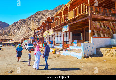 DAHAB, Egitto - 16 dicembre 2017: il piccolo villaggio turistico, situato sulla riva del Buco Blu snorkeling spot con la linea di caffè e montagne rocciose o Foto Stock