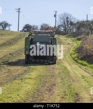 Castlehaven, West Cork, Irlanda, 27 marzo 2019. Un'altra bella giornata di primavera e il clima caldo ha permesso un allevatore locale per ottenere la sua prima stagione da insilato tagliato e imballato. Credito: aphperspective/Alamy Live News Foto Stock