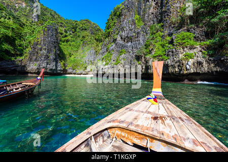 Wang Long Bay con cristallo acqua turchese, isola tropicale di Koh Phi Phi Don, Provincia di Krabi, Thailandia - lunga barca nella bellissima laguna con rocce coprire Foto Stock