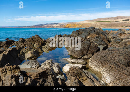 Spiaggia di Myponga con riflessioni in una piscina di roccia su una tranquilla e luminosa giornata di sole sulla penisola di Fleurieu in Sud Australia il 27 marzo 2019 Foto Stock