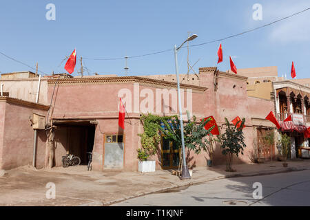 Corner House a Kashgar Città Vecchia con bandiere cinesi su ciascuno e ogni angolo (provincia dello Xinjiang, Cina) Foto Stock