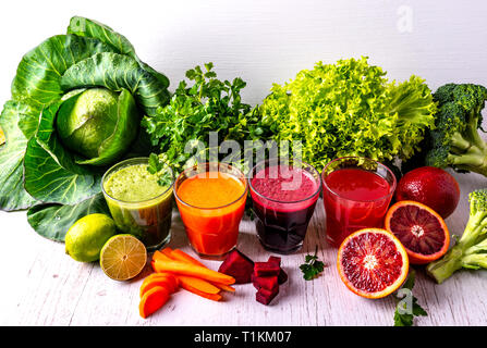 Diversi vegano sano bevande con frutta e verdura in bianco sullo sfondo di legno. Foto Stock