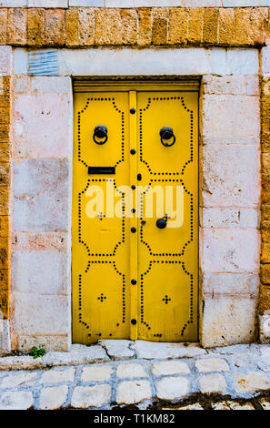 Tradizionale antica dipinta porta in un quartiere storico o medina, Tunisia. Coloratissima immagine con trama di architettura musulmana. Foto Stock