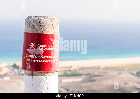 Post su Fuerteventura montagne informare gli escursionisti circa il sentiero. Segno dice: sentiero naturale. Sentieri naturali di Fuerteventura. Foto Stock