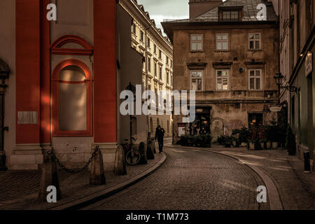 Uomo che cammina verso il basso Zautek Niewiernego Tomasza con Camelot cafe in background, Cracovia in Polonia Foto Stock