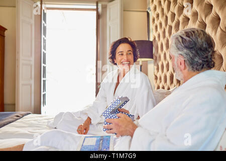 Felice Coppia matura in accappatoio sul letto Foto Stock