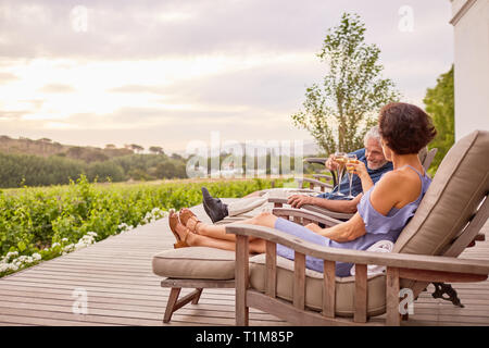 Coppia matura di tostatura flauti champagne su hotel patio Foto Stock