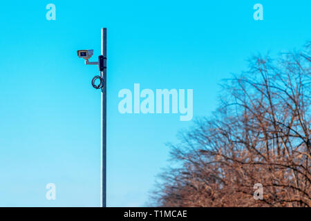 La vigilanza del traffico fotocamera montata sul montante con una grande porzione di cielo blu come spazio di copia Foto Stock