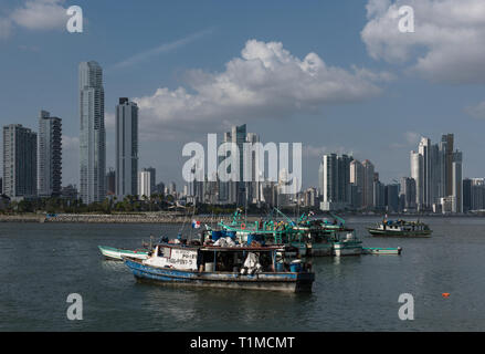 Vecchie barche da pesca vicino al mercato del pesce in Panama City con lo sfondo dello skyline di Foto Stock