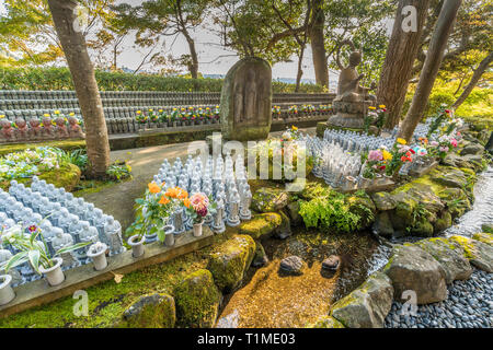 Righe di vecchi Jizo Bodhisattva (Bosatsu) statue raggruppati e flusso di acqua nei pressi di Jizo-fare Hall a Haze-dera tempio o-Hase Kannon. Foto Stock