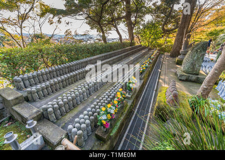 La mattina presto vista di righe di vecchi Jizo Bodhisattva (Bosatsu) statue raggruppate in prossimità Jizo-fare Hall a Haze-dera tempio o-Hase Kannon. Foto Stock