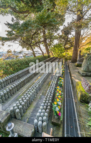 La mattina presto vista di righe di vecchi Jizo Bodhisattva (Bosatsu) statue raggruppate in prossimità Jizo-fare Hall a Haze-dera tempio o-Hase Kannon. Foto Stock