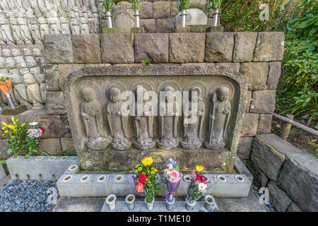 Righe di vecchi Jizo Bodhisattva (Bosatsu) statue raggruppate in prossimità Jizo-fare Hall a Haze-dera tempio o-Hase Kannon. Foto Stock