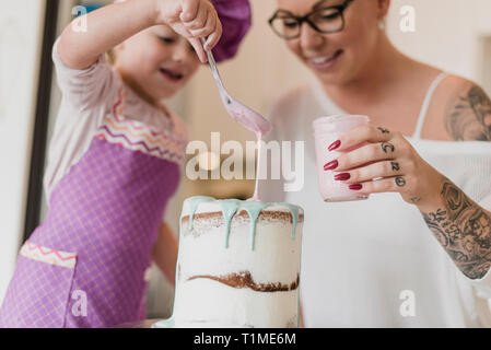 Madre e figlia decorare la torta Foto Stock