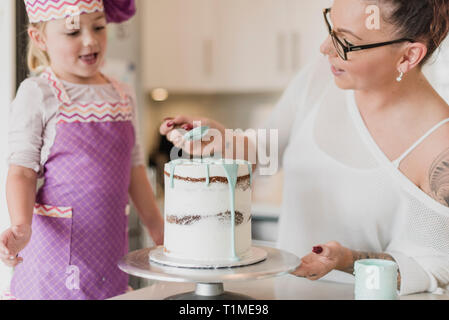 Madre e figlia decorare la torta Foto Stock