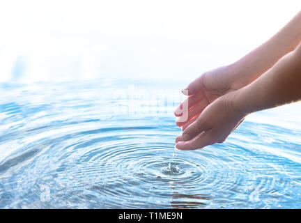 Acqua caduta da una mano Foto Stock