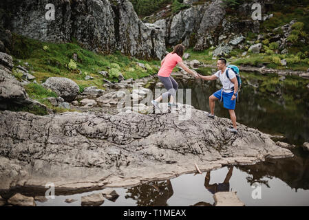 Escursionismo coppia sulle rocce, cane montagna, BC, Canada Foto Stock