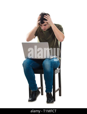 Sconvolto e ha sottolineato giovane uomo utilizzando laptop seduto su una sedia, tenendo le mani alla testa, isolato su sfondo bianco. Deluso freelancer guy workin Foto Stock