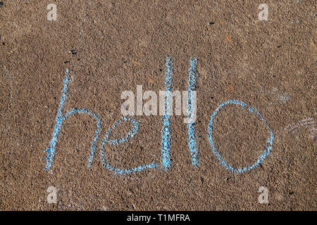 La parola Hello scritto con sidewalk chalk sul cemento grigio Sfondo marciapiede Foto Stock