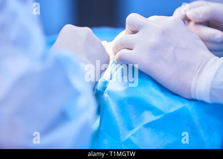 Il team medico di chirurghi in ospedale facendo minimamente invasivo di interventi chirurgici. La chirurgia sala operatoria con apparecchiature di elettrocauterizzazione per cardiovas Foto Stock