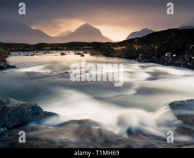 La silhouette di Marsco contro la luce in un giorno nuvoloso dal fiume Allt Dearg Mor. Foto Stock