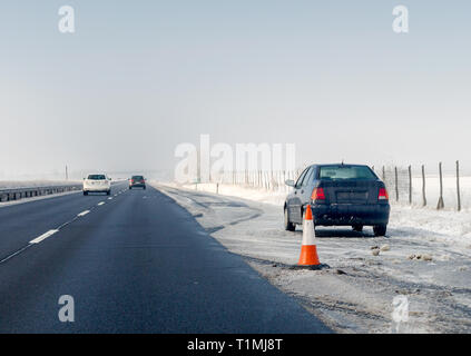 Guasto Auto e cono di traffico su arresto di emergenza lane sul ciglio della strada. Problema con il veicolo sulla strada d'inverno. Spazio per il testo Foto Stock