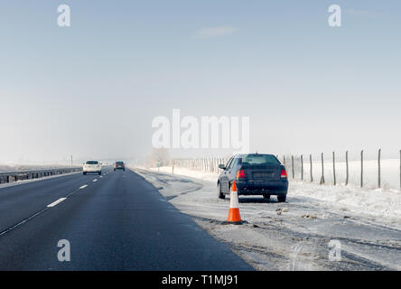 Guasto Auto e cono di traffico su arresto di emergenza lane sul ciglio della strada. Problema con il veicolo sulla strada d'inverno. Spazio per il testo Foto Stock