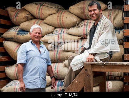 Lavoratori di caffè con carichi di sacco di chicchi di caffè in Filandia, Colombia Foto Stock