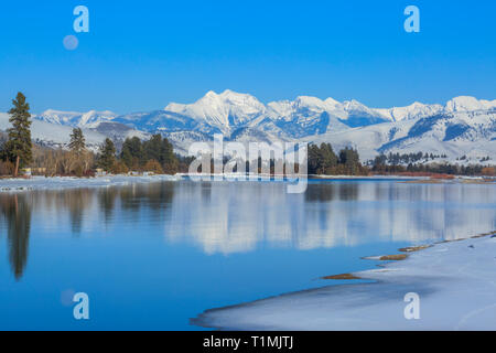 Luna crescente oltre il fiume flathead e missione le montagne in inverno vicino a Dixon, montana Foto Stock