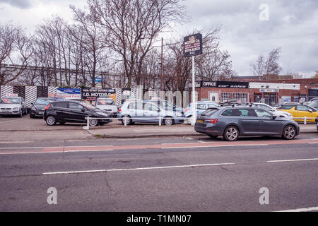 Vista generale dalla strada di un automobile usata vendita piazzale antistante su un auto di seconda mano passo di vendite a lato della strada Foto Stock