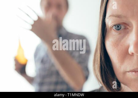 Uomo ubriaco bere birra e sostenendo con la moglie a casa, caucasico adulto giovane nella controversia interna concept a urlare contro l'altra. Foto Stock