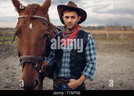 Cowboy pone a cavallo sul texas farm Foto Stock