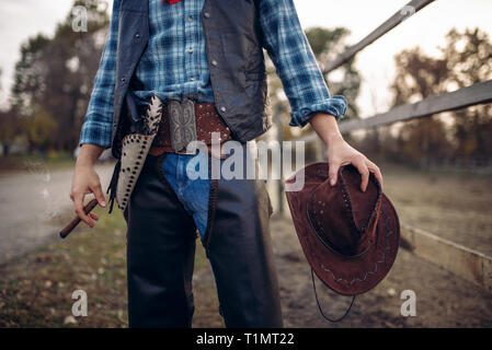 Cowboy in indumenti di cuoio Indumenti di cuoio pone con cigare Foto Stock