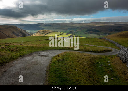 Guardando attraverso la campagna verso il basso una pista vicino la torta verso Conistone (vicino Kettlewell) dalla torta sperone roccioso nel Yorkshire Dales, REGNO UNITO Foto Stock