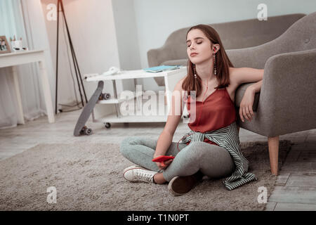 Giovane donna ascoltando la musica a casa Foto Stock