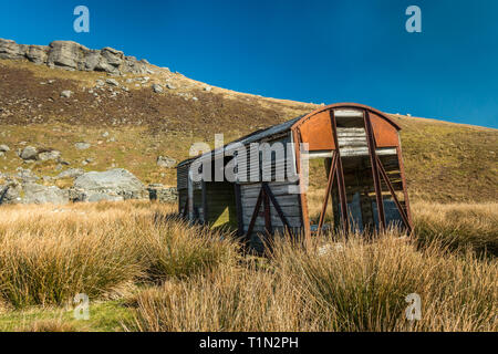 Riutilizzato merci ferroviario trasporto, ora capannone o granaio, in bella luce e cielo blu su the moorland road, tra Nateby e Thwaite in Swaledale superiore Foto Stock