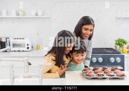 Madre e figli di cottura muffin al cioccolato Foto Stock