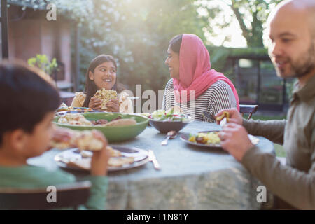 Famiglia di mangiare la cena al tavolo del patio Foto Stock
